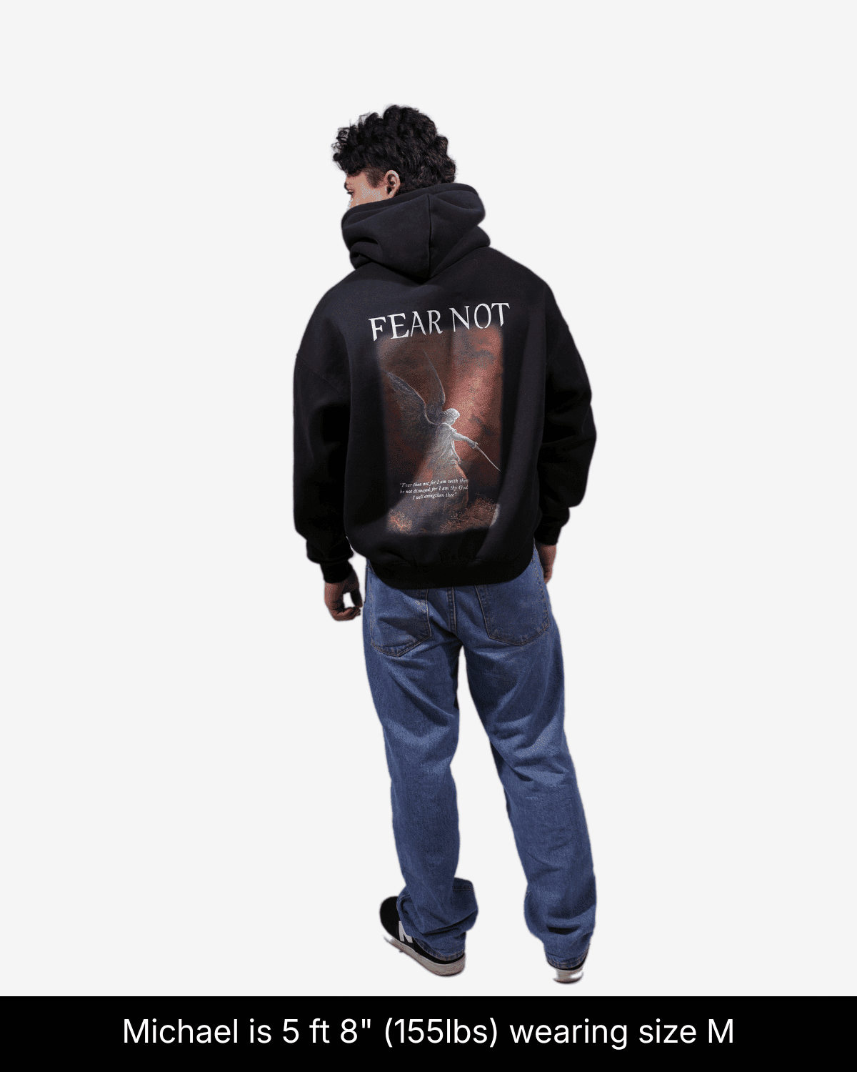 Model wearing black Fear Not hoodie, showing a red angel graphic and Fear Not lettering on the back in size M.