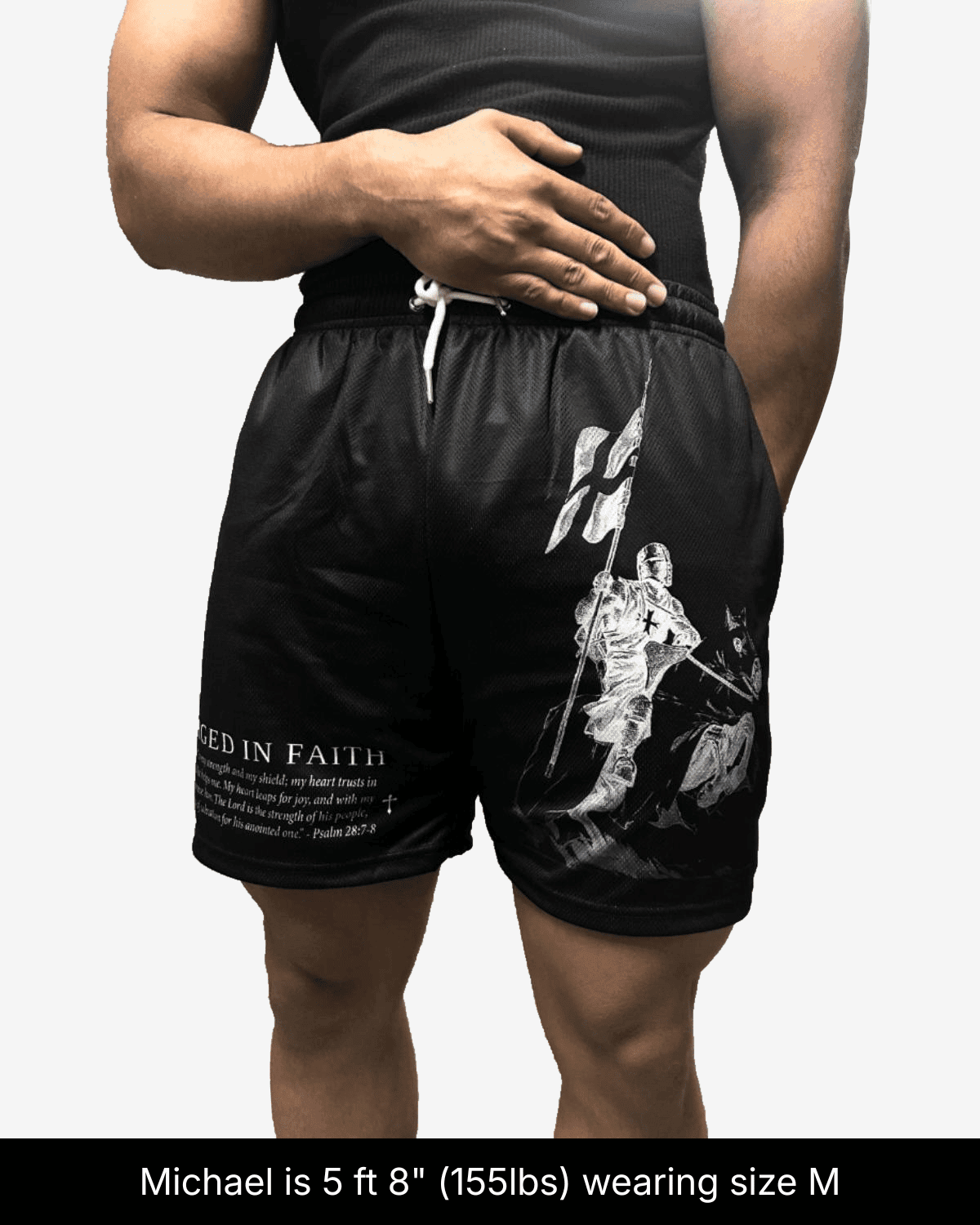 Model wearing black Forged in Faith shorts in size M, showing a white knight and flag graphic.