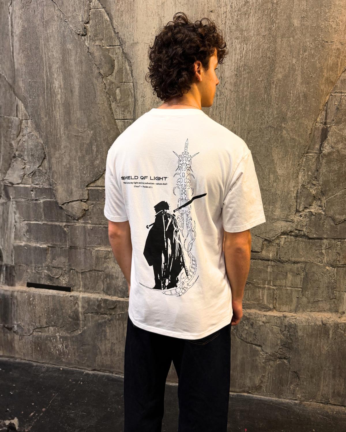 Shield Of Light faith based t-shirt white back graphic worn by model outdoor wall