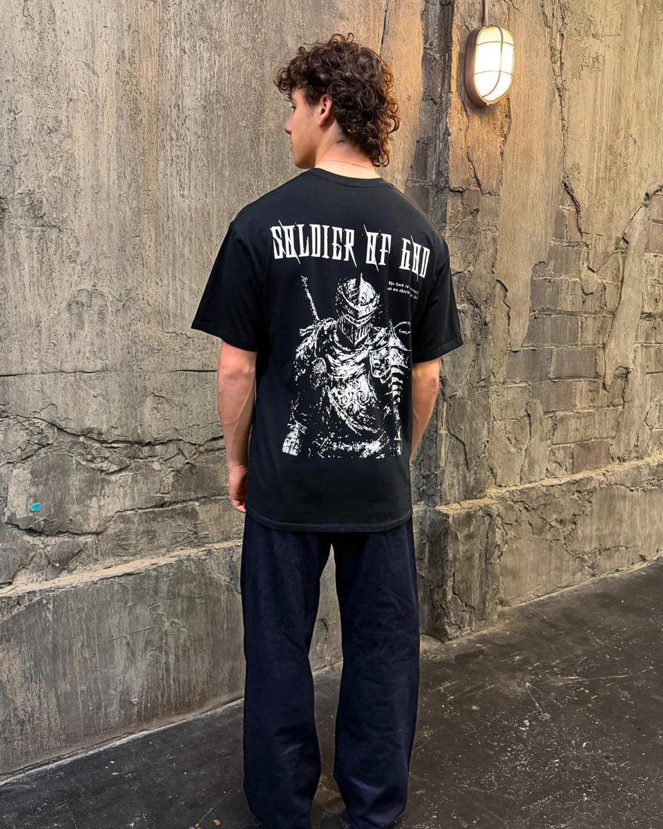 Soldier Of God faith based t-shirt black back graphic worn by model outdoor wall